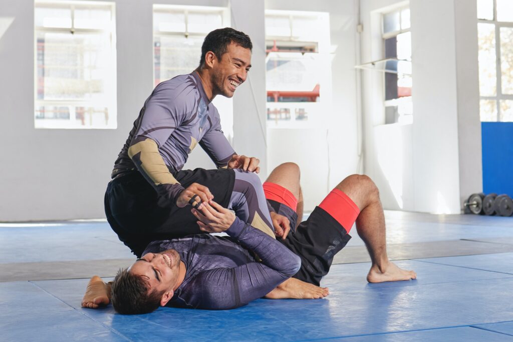 Full length shot of a jiu jitsu sensei sparring with one of his students during a class